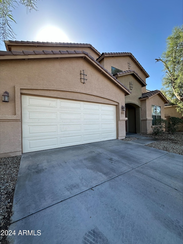 mediterranean / spanish home featuring a garage