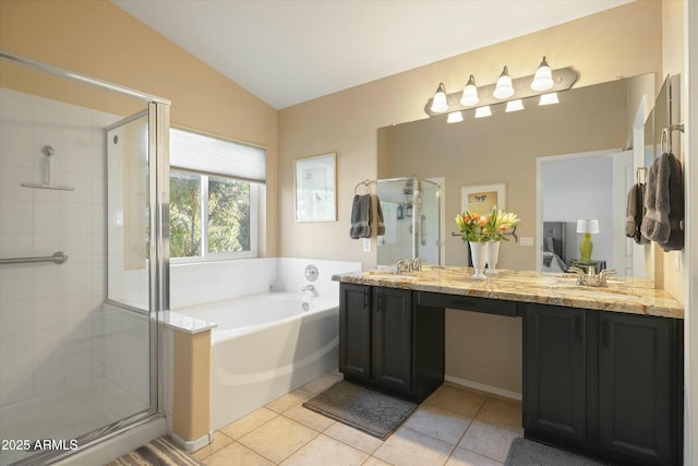 ensuite bathroom featuring a garden tub, a sink, vaulted ceiling, tile patterned floors, and a stall shower