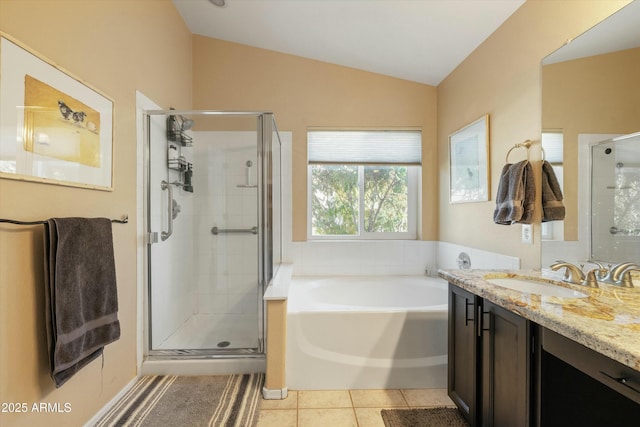 bathroom featuring a stall shower, a garden tub, tile patterned flooring, vaulted ceiling, and vanity