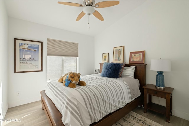 bedroom featuring lofted ceiling, baseboards, ceiling fan, and light wood finished floors