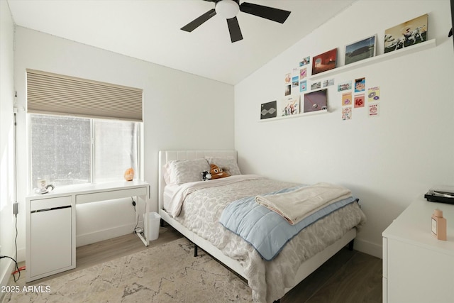 bedroom featuring a ceiling fan, vaulted ceiling, and wood finished floors