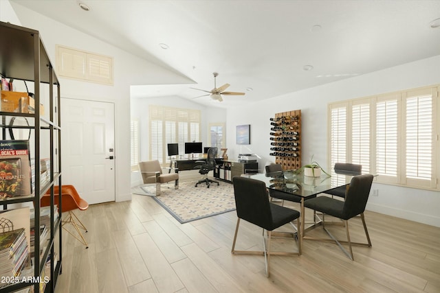 dining area with lofted ceiling, ceiling fan, light wood-type flooring, and baseboards