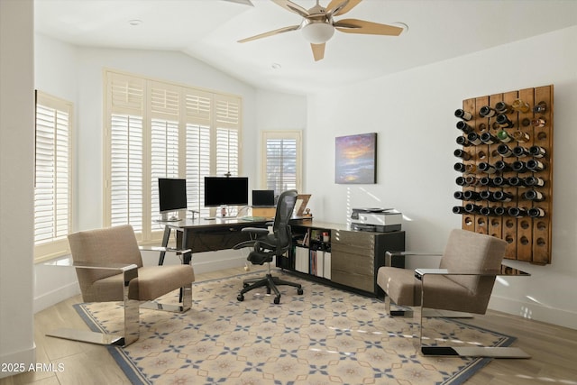 office space with baseboards, vaulted ceiling, light wood finished floors, and ceiling fan