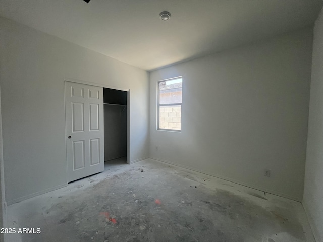 unfurnished bedroom with baseboards and a closet