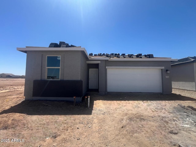 view of front facade with a garage, stucco siding, and driveway