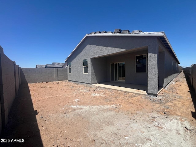 back of property featuring a fenced backyard, a patio area, and stucco siding