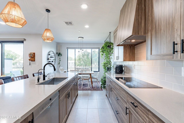 kitchen featuring pendant lighting, sink, plenty of natural light, dishwasher, and black electric stovetop