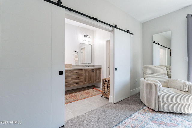 interior space with sink, ensuite bathroom, and a barn door