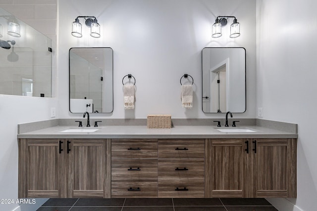 bathroom featuring tile patterned flooring, vanity, and a shower with shower door