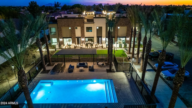 pool at dusk featuring a patio area