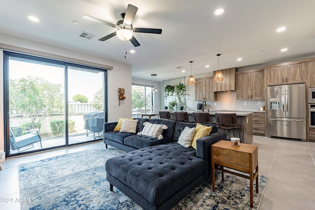 tiled living room with sink and ceiling fan