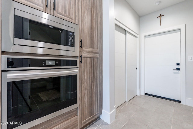 kitchen with stainless steel appliances and light tile patterned flooring