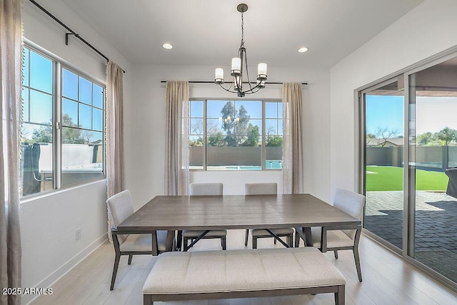 dining area featuring light wood-style flooring, a chandelier, baseboards, and recessed lighting