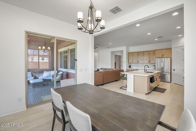 dining area with light wood-type flooring, visible vents, recessed lighting, and an inviting chandelier