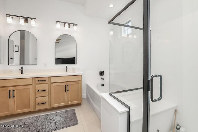 full bathroom featuring double vanity, tile patterned flooring, a sink, and a bath