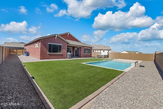 rear view of property featuring a fenced backyard, a yard, a fenced in pool, stucco siding, and a patio area