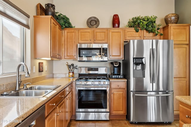 kitchen with light stone counters, sink, light tile patterned floors, and stainless steel appliances