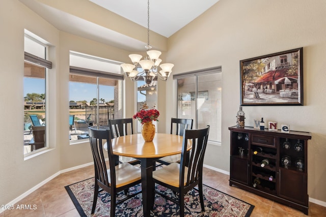 dining area featuring lofted ceiling, light tile patterned floors, and a notable chandelier