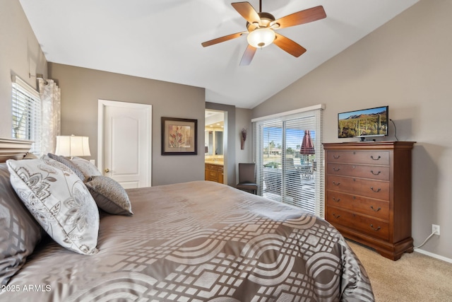 carpeted bedroom featuring ceiling fan, vaulted ceiling, and ensuite bath