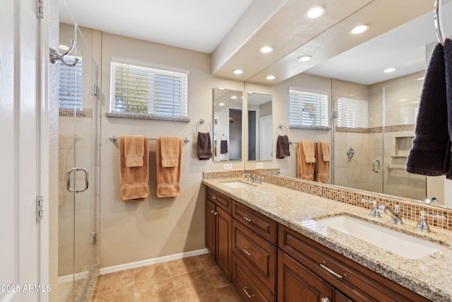 bathroom featuring vanity, a shower with door, and decorative backsplash