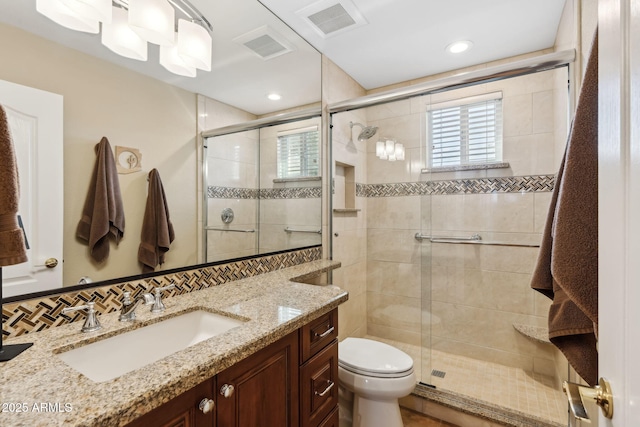 bathroom featuring vanity, toilet, an enclosed shower, and backsplash