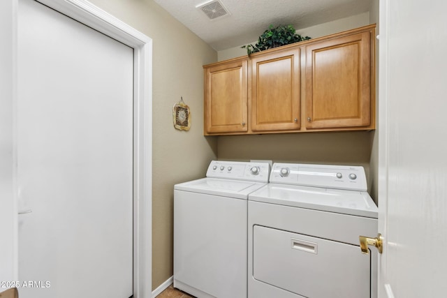 laundry area featuring separate washer and dryer and cabinets