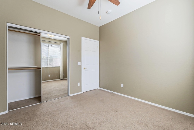 unfurnished bedroom with a closet, carpet flooring, ceiling fan, and baseboards