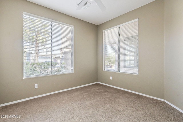 unfurnished room featuring a ceiling fan, carpet, a healthy amount of sunlight, and baseboards