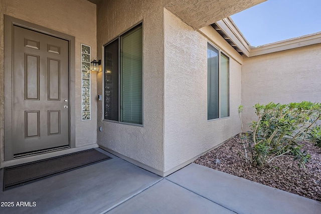 view of exterior entry with stucco siding