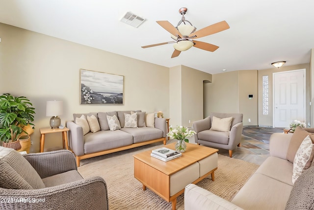 living area with baseboards, visible vents, and a ceiling fan