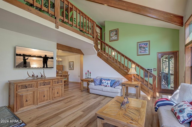 living room featuring beamed ceiling, high vaulted ceiling, light hardwood / wood-style floors, and an inviting chandelier