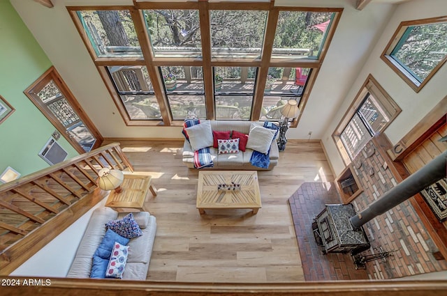 living room featuring plenty of natural light, a wood stove, and wood-type flooring