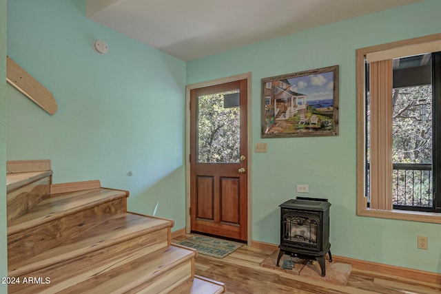 entryway featuring a wood stove and hardwood / wood-style floors