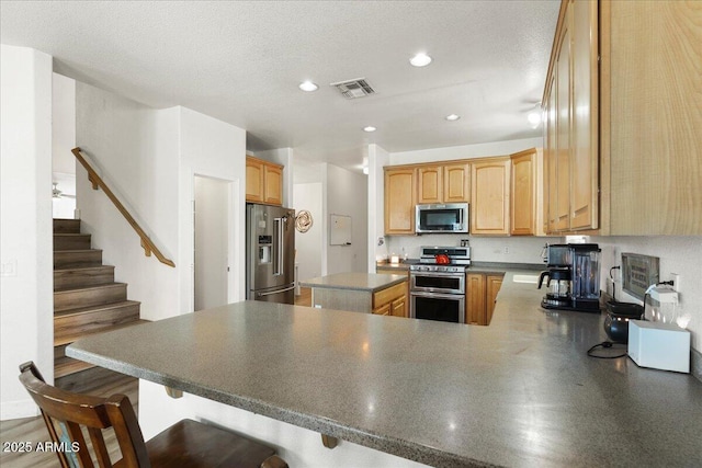 462 W Myrtle Dr, Chandler, AZ 85248 - kitchen featuring appliances with stainless steel finishes, a peninsula, dark countertops, recessed lighting, and a breakfast bar