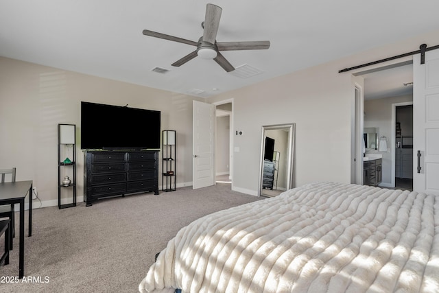 carpeted bedroom featuring a barn door, connected bathroom, and ceiling fan