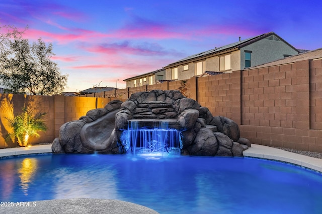 pool at dusk with pool water feature