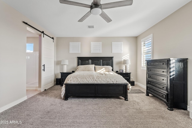 carpeted bedroom featuring ceiling fan and a barn door