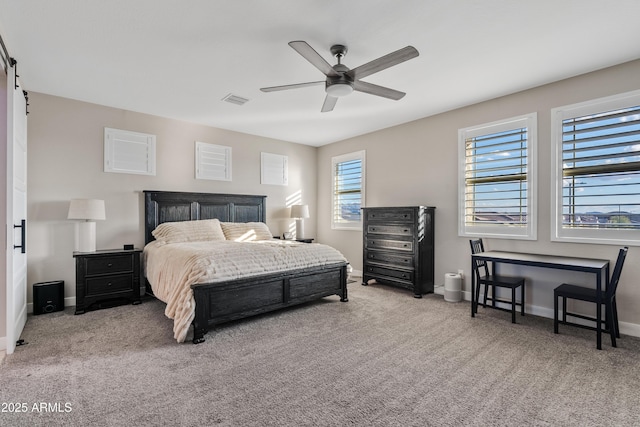 carpeted bedroom featuring ceiling fan and a barn door