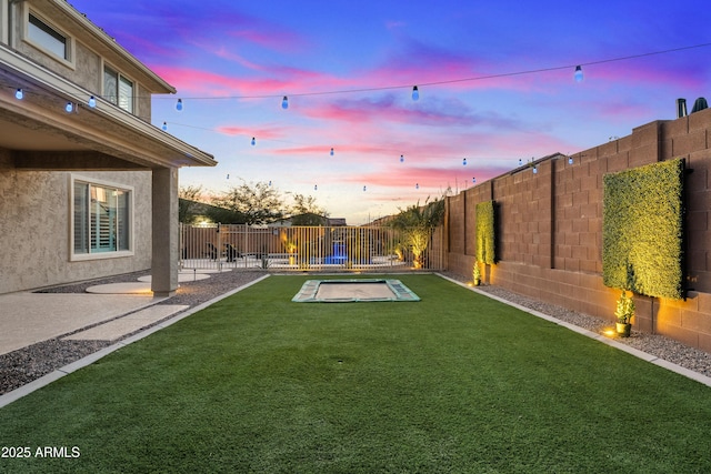 yard at dusk featuring a pool and a patio