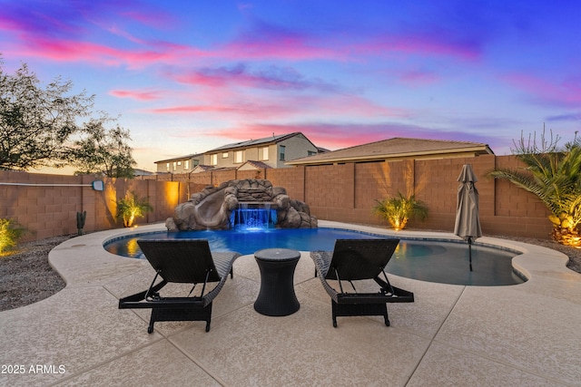 pool at dusk with a patio area, pool water feature, and a water slide