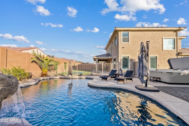 view of pool with a hot tub, a patio, and pool water feature