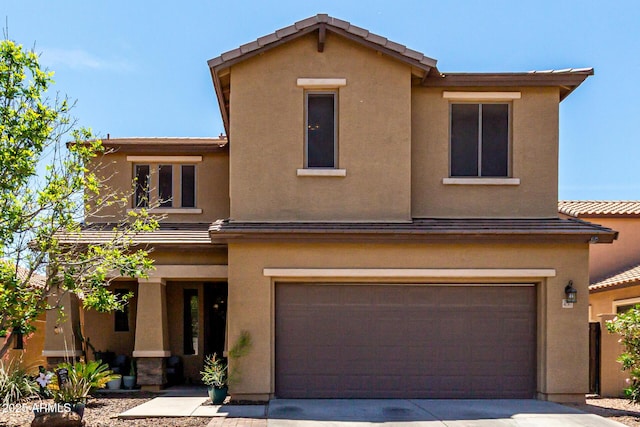 view of front of house with a garage, stucco siding, and concrete driveway