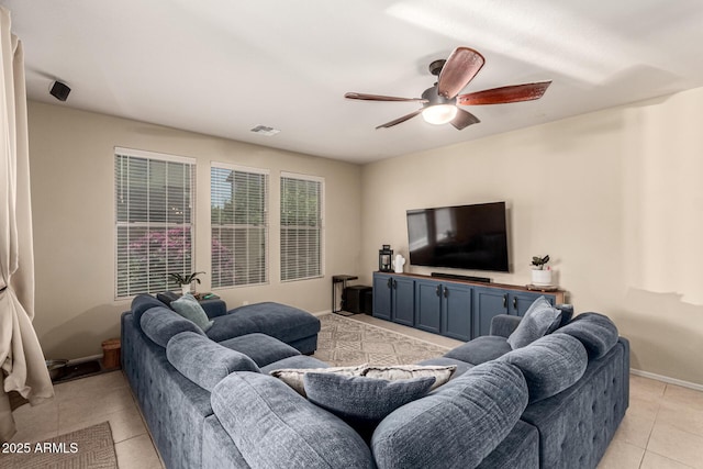 living area with a ceiling fan, baseboards, visible vents, and light tile patterned floors