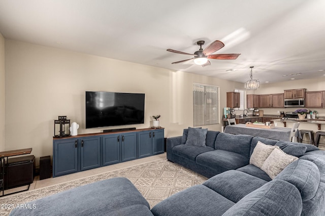 living area featuring ceiling fan with notable chandelier and light tile patterned floors