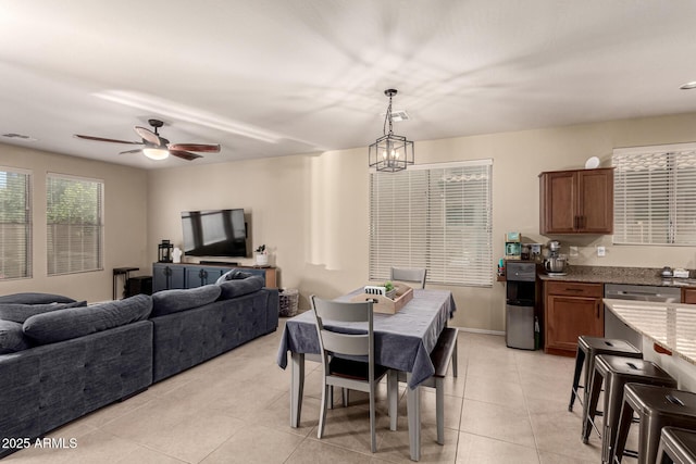 dining area with visible vents, light tile patterned floors, and ceiling fan with notable chandelier