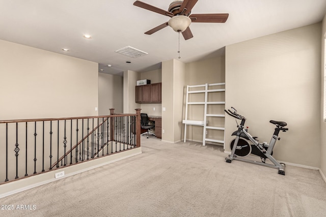 workout area featuring baseboards, visible vents, and light carpet