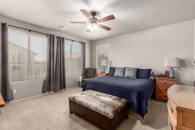 bedroom with visible vents, baseboards, ceiling fan, and light carpet