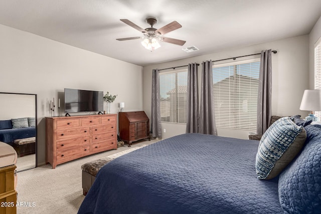 carpeted bedroom featuring a ceiling fan and visible vents