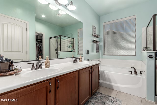 bathroom with tile patterned flooring, a sink, a garden tub, and a stall shower