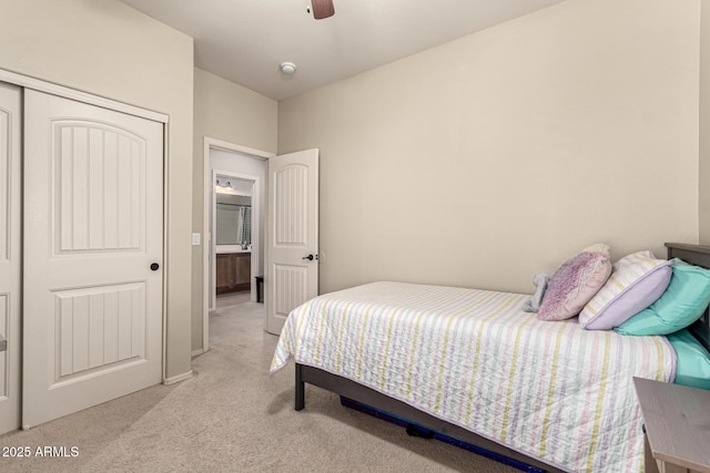 bedroom featuring a ceiling fan, light carpet, and a closet